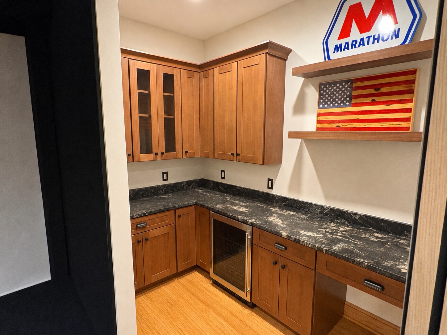 Golfers Paradise basement — wet bar with custom cabinetry, granite countertops, beverage fridge, and floating shelves by Luxe Built Louisville KY